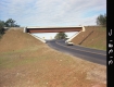 Car on Road Past Bridge
