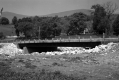 Completed Bridge Construction Over Small River With Dwelling