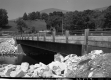 Completed Bridge Construction Over Small River With Dwelling 
