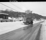Snow Plow on Road by Houses
