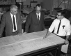 Three Engineers Standing Around Table