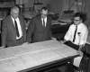 Three Engineers Standing Around Table