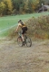 Female bike racer rides across a field