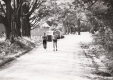 Two runners on a dirt road with a barn