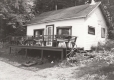 A small white cottage with a porch