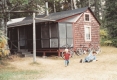 Small cottage with a man and toddler on the lawn