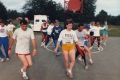 Fifteen people move about on a basketball court