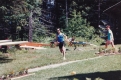 A man running past rowing shells and flowers